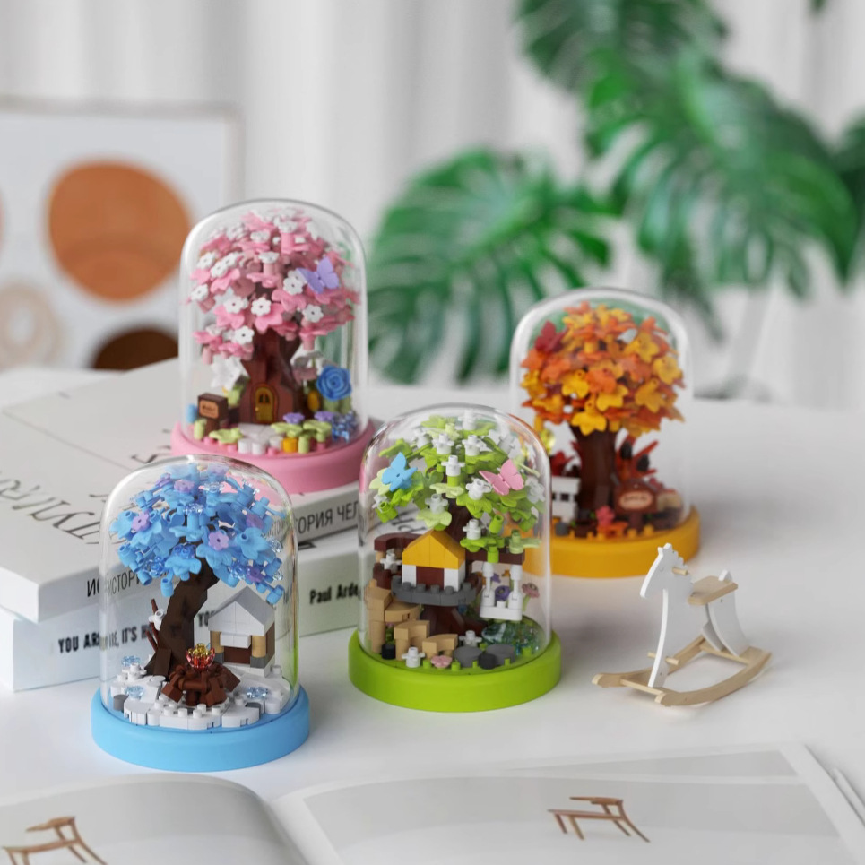 Set of miniature dioramas with trees and houses inside transparent domes on a white surface.